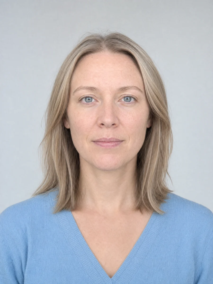 A woman with ash blonde hair, gray-blue eyes and a powder blue knit top.